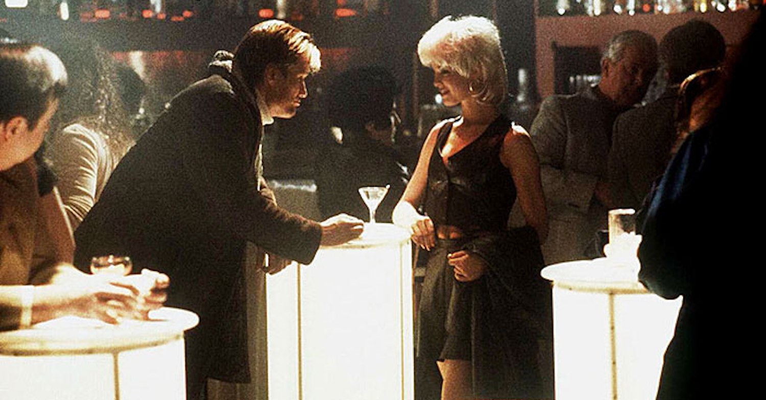 L'homme ne sait pas encore que la séduisante jeune blonde debout en face de lui à l'intérieur du club est une fabuleuse Maîtresse sadomasochiste dans le film Jill the killer en 1999