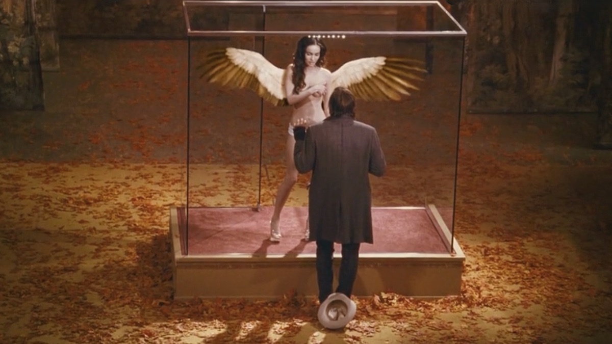 Megan Fox est une femme ange emprisonnée dans une cage de verre pour être exhibée devant des hommes vicieux dans le film Passion Play de Mitch Glazer en 2010