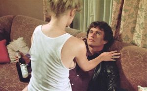 Melanie Griffith altière et magnétique chevauche Tom Berenger en buvant une gorgée de son bourbon avant de l'embrasser sur la bouche dans le film New York 2H00 du matin en 1984