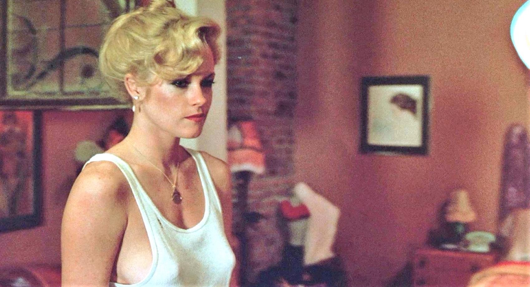 Melanie Griffith révèle ses tétons sous un débardeur blanc pour mieux séduire l'homme qui l'emploie et la protège dans le film New York 2H00 du matin en 1984