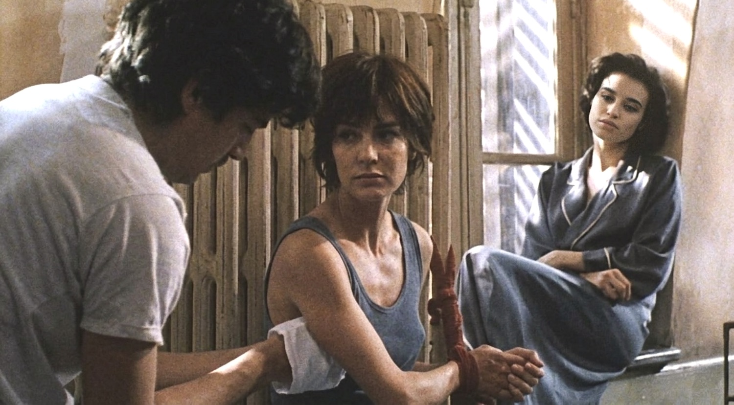 Alice est incarnée par Anne Parillaud captive ligotée à un radiateur par son amant et sa sœur Elsa interprétée par Béatrice Dalle qui vont faire l'amour ensemble en commettant leur pénétration adultère à côté de la jeune prisonnière afin d'accroître son humiliation dans le film À la folie en 1994