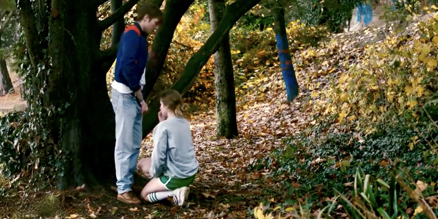Une jeune femme à genoux regarde la main de l'homme qui va sortir le pénis de son pantalon pour une fellation dans le film Crache cœur en 2015