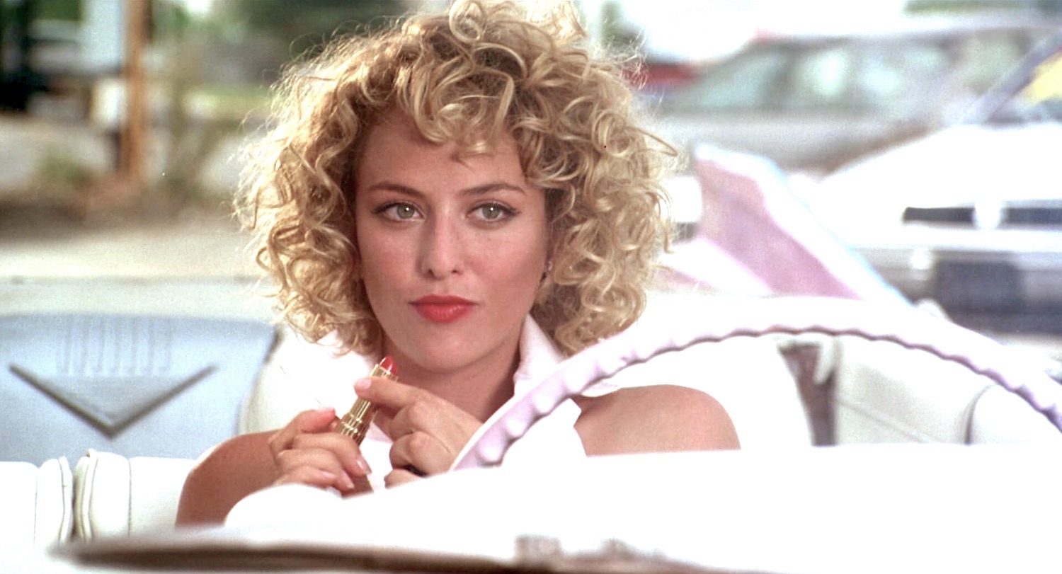 Virginia Madsen incarne la très sexy Dolly Harshaw femme mariée à un concessionnaire automobile d'une petite ville du Texas qui fait cocu son mari avec un de ses vendeurs dans le film Hot Spot en 1990