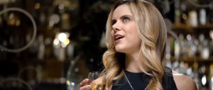 Elisabeth Hower interprète Christen durant le dîner d'anniversaire à l'intérieur d'un restaurant de luxe avant que la jeune femme nue se retrouve encagée et exhibée en public sur des moniteurs vidéo dans le film Escape Room en 2017