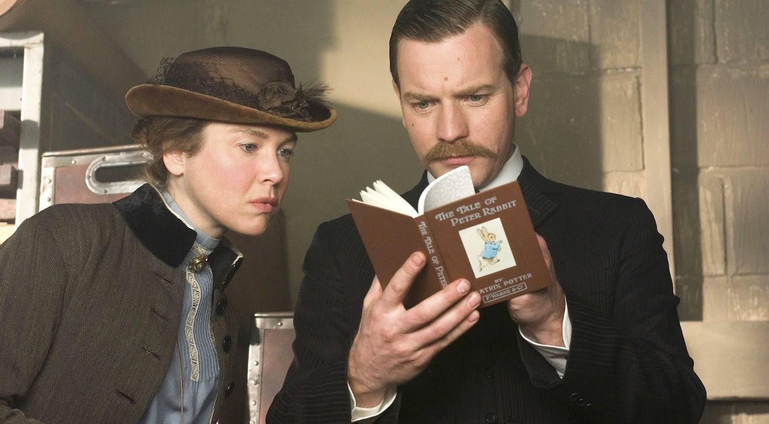 Beatrix Potter interprétée par Renée Zellweger et Norman Warne interprété par Ewan McGregor examinent une édition de leur célèbre livre The Tale of Peter Rabbit dans le film Miss Potter en 2006
