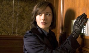 Catherine Zeta-Jones porte un gant de cuir noir symbole de son autorité et de sa puissance féminine en interprétant une inspectrice d'Europol face à des cambrioleurs dans le film Ocean’s Twelve en 2004