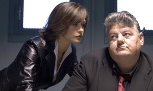 Le recéleur Matsui incarné par Robbie Coltrane subit un interrogatoire mené par Isabel Lahiri incarnée par Catherine Zeta-Jones qui démontre comment une femme dominante sait faire plier les hommes dans le film Ocean’s Twelve en 2004