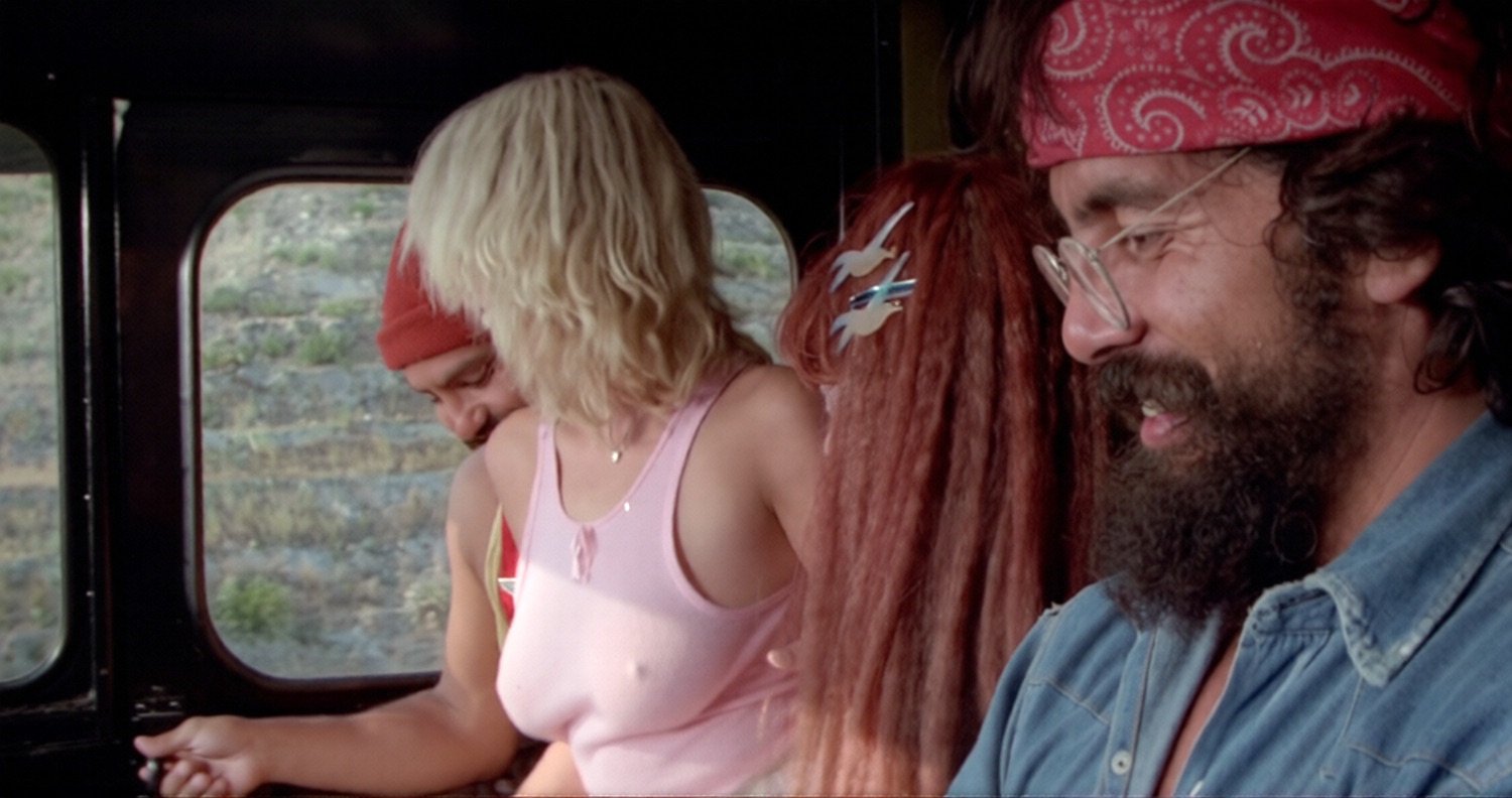 Wally Ann Wharton en débardeur rose est une autostoppeuse qui sait mettre en valeur ses atouts féminins sans la moindre pudeur devant Cheech Marin et Tommy Chong dans le film Faut trouver le joint en 1978