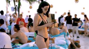 CW incarnée par Cassandra Naud révèle les bords de son pubis épilé avec un bikini très échancré à la piscine du Finns Beach Club à Bali en Indonésie afin de séduire les hommes qu'elle rencontre grâce aux réseaux sociaux dans le film Influencers en 2025