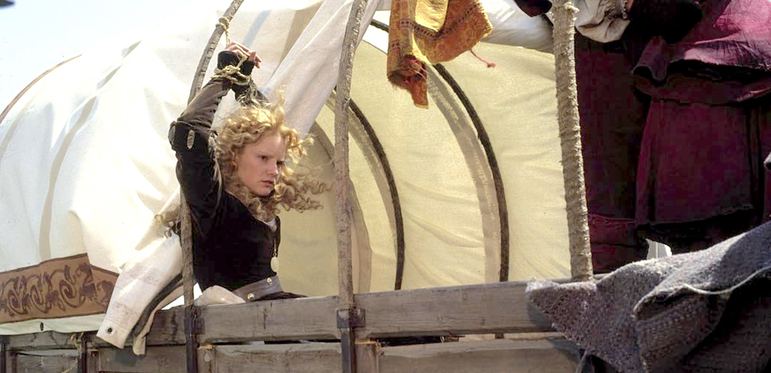 Agnès interprétée par Jennifer Jason Leigh attachée à l'arrière d'une charrette après avoir été capturée dans le film médiéval La Chair et le Sang en 1985