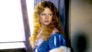 Jennifer Jason Leigh incarne la jolie Agnès avec sa robe bleue de jeune noble avant d'être faite prisonnière et abusée dans le film La Chair et le Sang en 1985