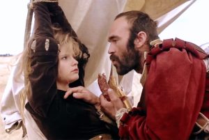 Un mercenaire suisse va introduire la saucisse à l'intérieur de la bouche de Jennifer Jason Leigh qui joue Agnès puis l'homme se met debout pour déboutonner son pantalon devant le visage de la jeune femme dans le film La Chair et le Sang en 1985