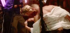 La jeune femme blonde aux cheveux courts sur un sling qui s'offre à un riche client à l'intérieur d'un club BDSM et libertin est une Artificielle destinée à satisfaire toutes les perversions des hommes dans le film Vice en 2015